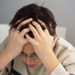 Stressed Schoolboy with Head in Hands